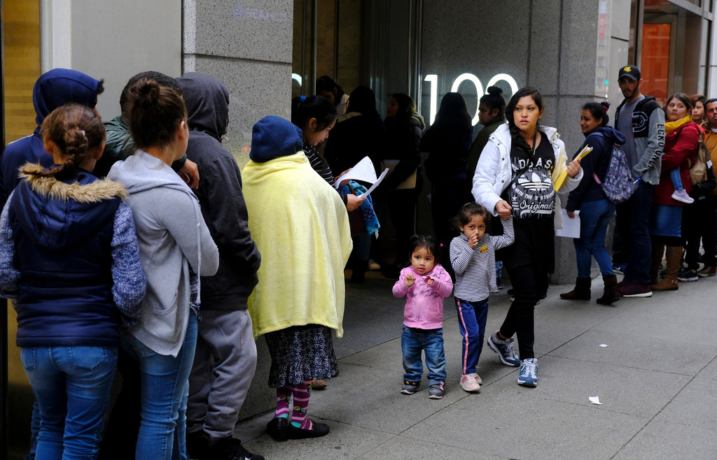 FILE - Hundreds of people stand in line outside a U.S. immigration office with numerous courtrooms in San Francisco, Jan. 31, 2019. (AP Photo/Eric Risberg, File)