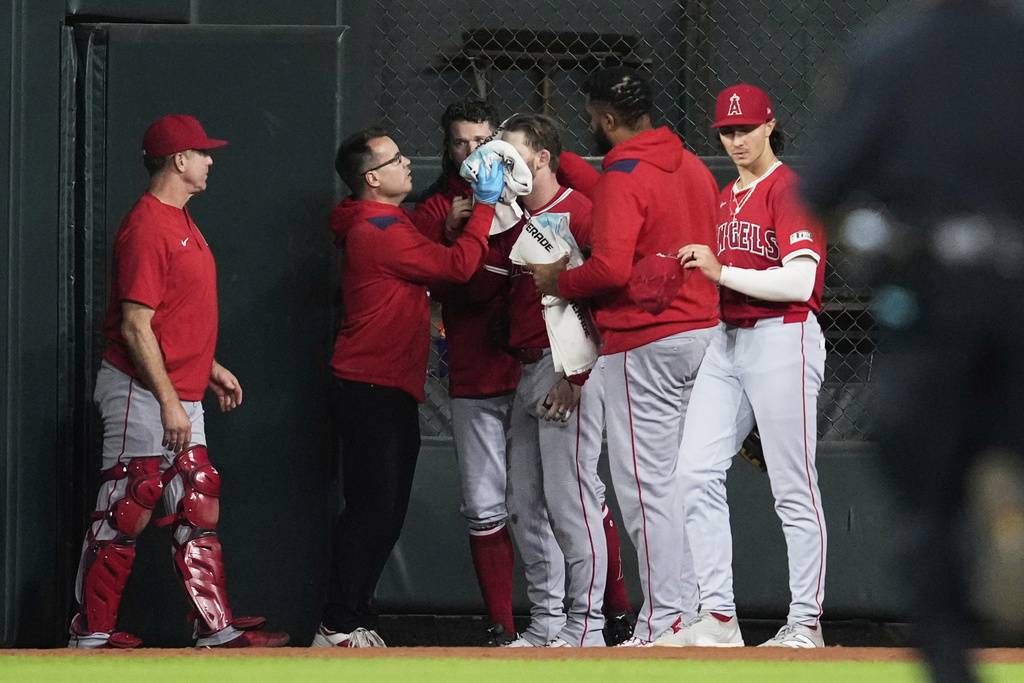 Los Angeles Angels left fielder Taylor Ward, center, is treated for injury during the eighth inning of a baseball game against the Houston Astros in Houston, Sunday, Aug. 31, 2025. (AP Photo/Ashley Landis)