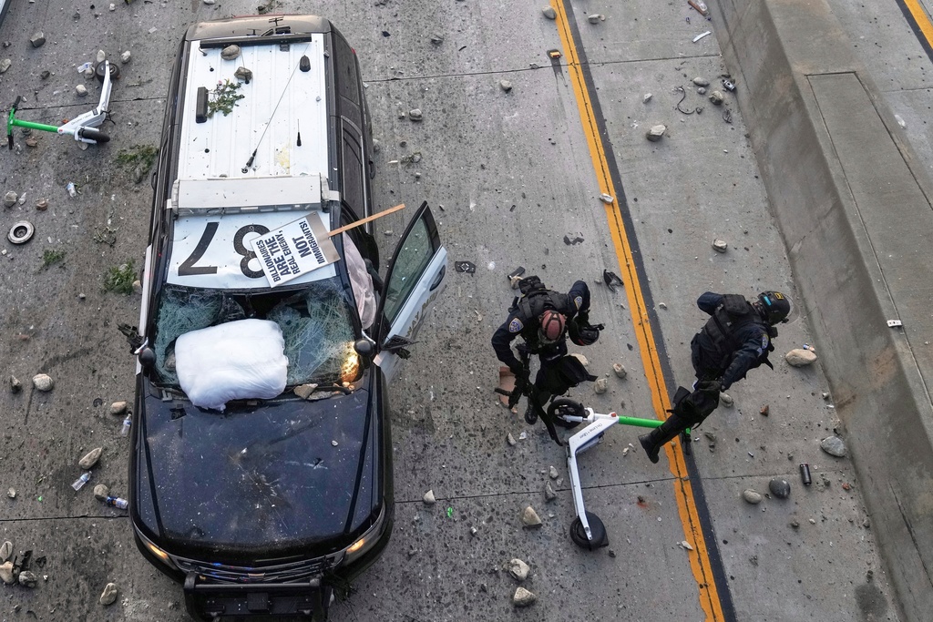Two California Highway Patrol officers try to dodge rocks being thrown near the Metropolitan Detention Center in downtown Los Angeles, June 8, 2025, following an immigration raid protest the night before. (AP Photo/Jae C. Hong, File)