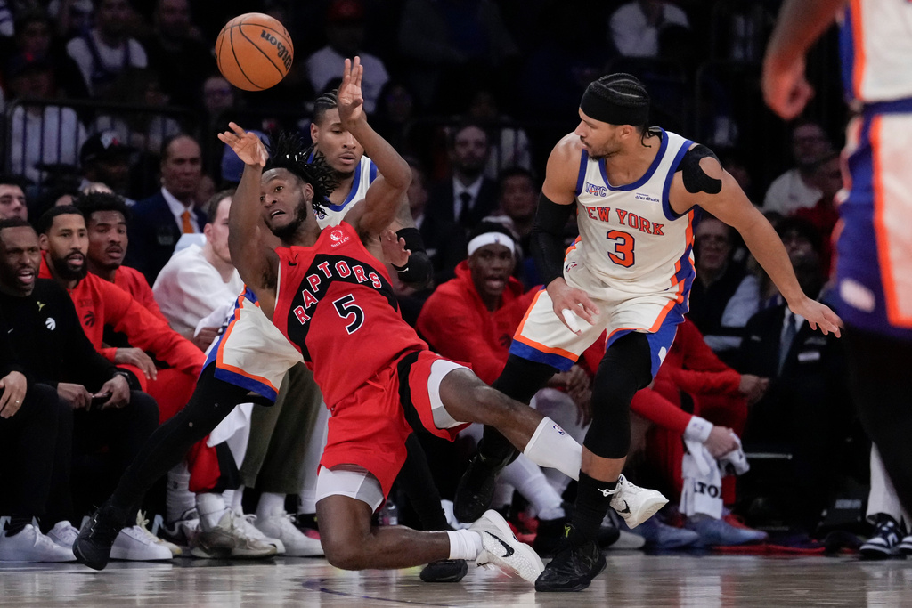 Toronto Raptors guard Immanuel Quickley (5) throws the ball away from New York Knicks guard Josh Hart (3) during the first half of an NBA basketball game Sunday, Nov. 30, 2025, in New York. (AP Photo/Yuki Iwamura)