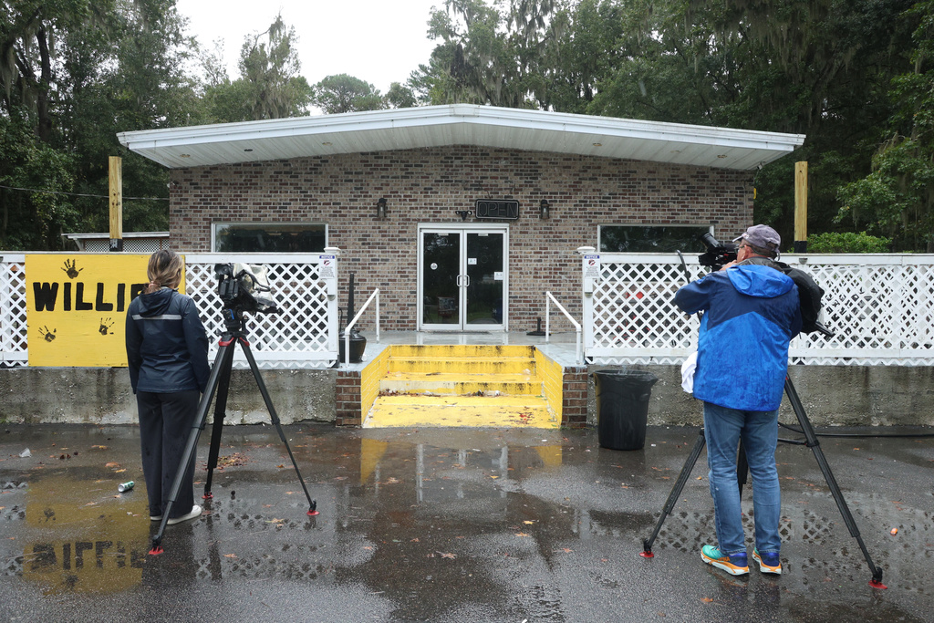 People take video outside of Willie's Bar and Grill in St Helena Island, S.C. after a shooting occurred early Sunday, Oct. 12, 2025. (AP Photo/Lewis M. Levine)