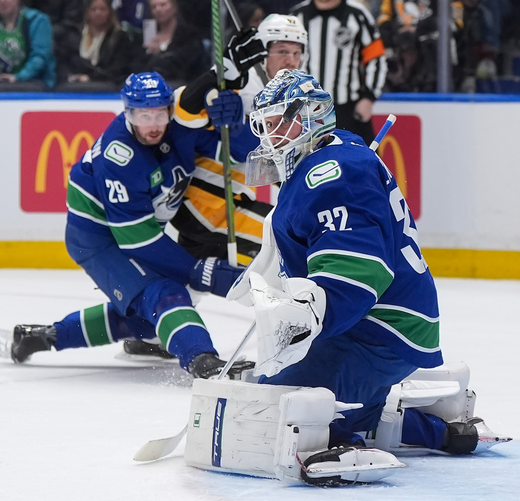 Vancouver Canucks goalie Kevin Lankinen (32) watches the puck after making a save during first-period NHL hockey game action against the Pittsburgh Penguins in Vancouver, British Columbia, Sunday, Jan. 25, 2026. (Darryl Dyck/The Canadian Press via AP)