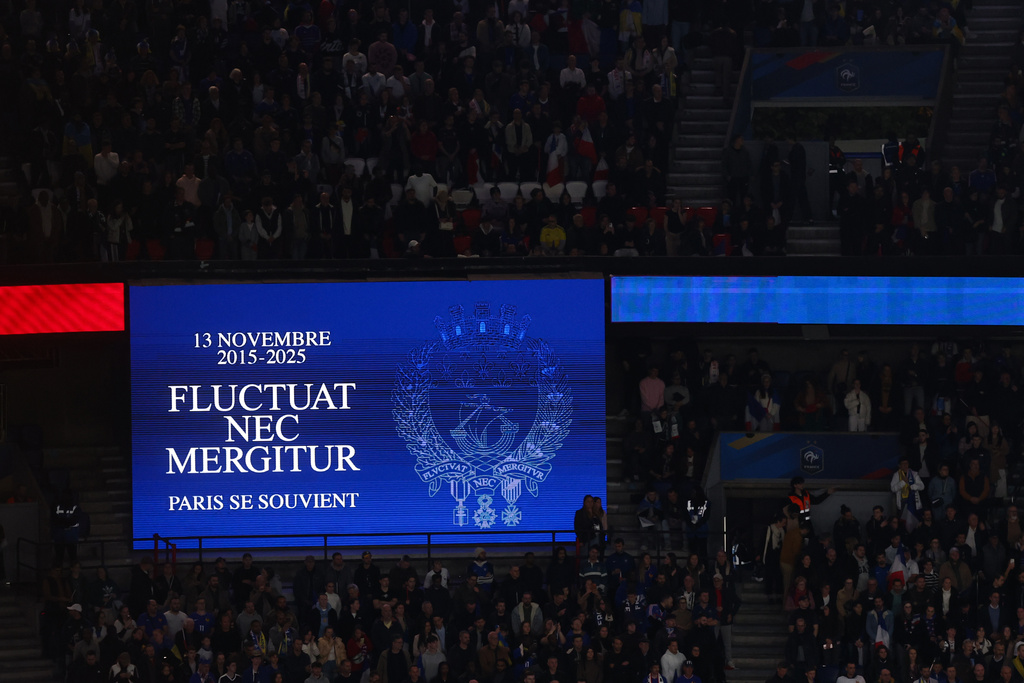 A screen reading Paris' motto "It is rocked by the waves, but does not sink" during a minute of silence in tribute for the victims of the Nov.13, 2015 Paris attacks, ahead of the 2026 World Cup qualifiers Europe zone group D football match between France and Ukraine at the Parc des Princes stadium, Thursday, Nov. 13, 2025 in Paris. ( Franck Fife, Pool photo via AP)