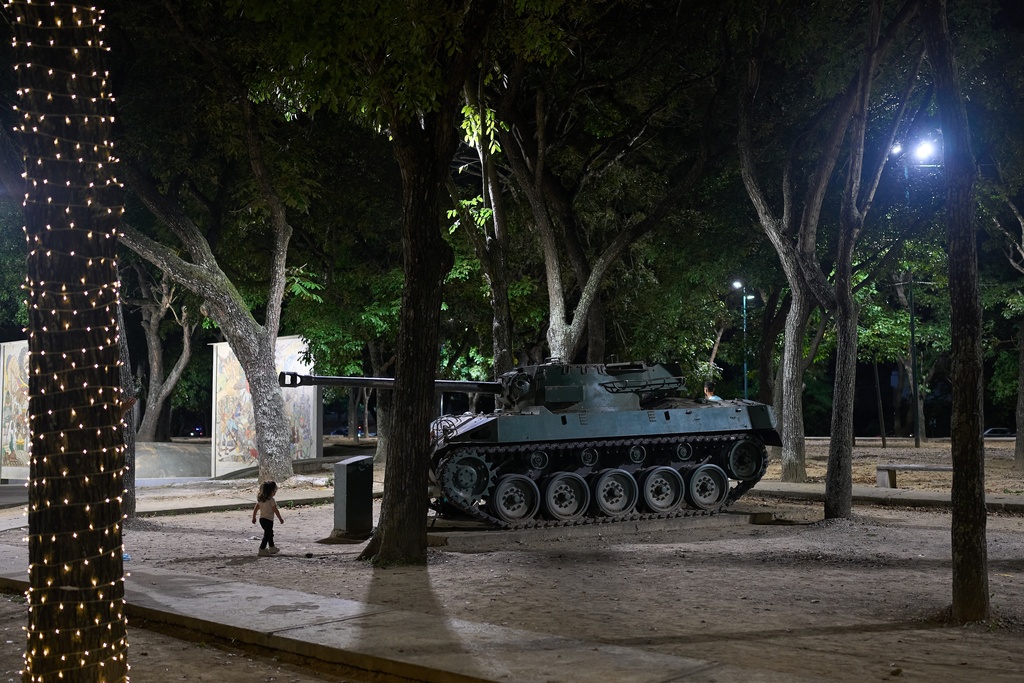 FILE - A child walks toward an armored vehicle on display at Paseo Los Proceres, a monumental walkway honoring heroes of independence, in Caracas, Venezuela, Dec 6, 2025. (AP Photo/Ariana Cubillos, File)
