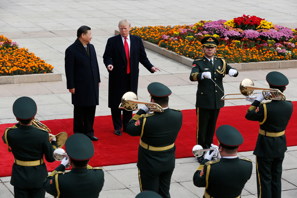 FILE - U.S. President Donald Trump, center, gestures to Chinese President Xi Jinping as they listen to the band music during a welcome ceremony at the Great Hall of the People in Beijing, Nov. 9, 2017. (AP Photo/Andy Wong, File)