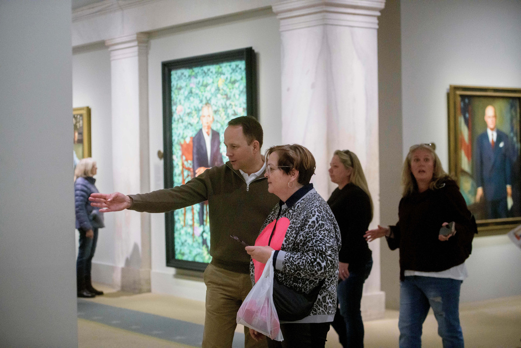 People react to a photograph of President Donald Trump on display at the Smithsonian's National Portrait Gallery's "American Presidents" exhibit on Sunday, Jan. 11, 2026 in Washington. (AP Photo/Rod Lamkey, Jr.)