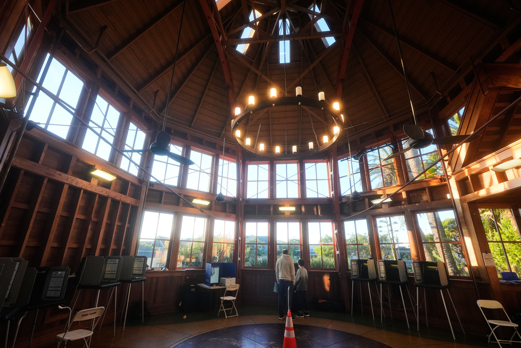 Seth Herring votes as his son watches at the Sunnyside Conservatory on Tuesday, Nov. 4, 2025, in San Francisco. (AP Photo/Jeff Chiu)