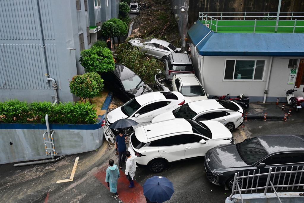 Vehicles are stuck near debris after a landslide caused by heavy rains in Geoje, South Korea, Monday, Aug. 17, 2026. (Cha Yong-hyun/Newsis via AP)