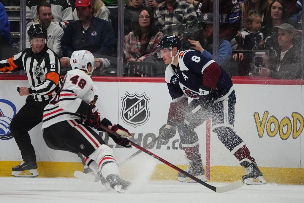 Colorado Avalanche defenseman Cale Makar, right, looks to pass the puck as Chicago Blackhawks defenseman Matt Grzelcyk covers in the second period of an NHL hockey game Saturday, Feb. 28, 2026, in Denver. (AP Photo/David Zalubowski)