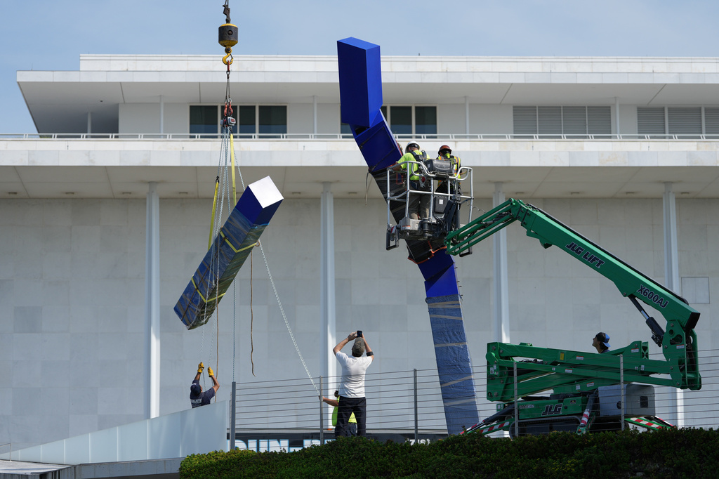 Workers remove the sculpture "Blue" by artist Joel Shapiro on the grounds of the John F. Kennedy Center for the Performing Arts in Washington, Wednesday, Sept. 2, 2026. (AP Photo/Mark Schiefelbein)
