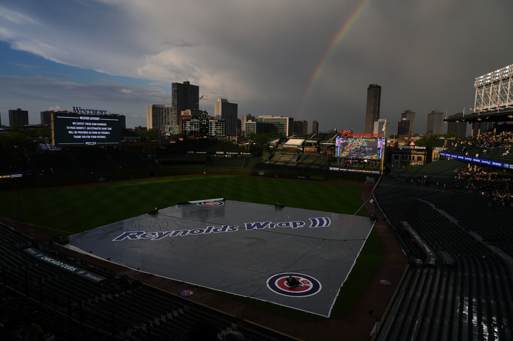 A rainbow occurs while a tarp covers the infield during a rain delay before a baseball game between the Cincinnati Reds and the Chicago Cubs in Chicago, Monday, May 4, 2026. (AP Photo/Nam Y. Huh)