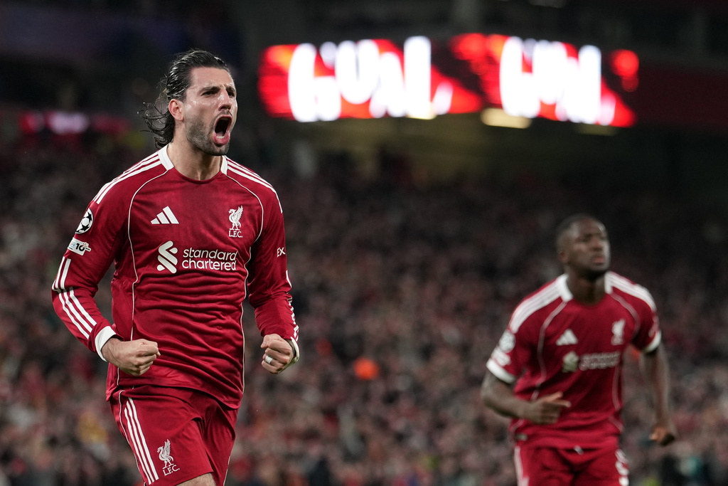 Liverpool's Dominik Szoboszlai, left, celebrates after scoring the opening goal during the second leg of the Champions League round of 16 soccer match between Liverpool and Galatasaray, in Liverpool, England, Wednesday, March 18, 2026. (AP Photo/Jon Super)