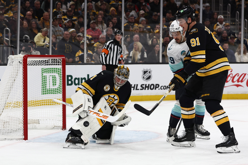 Boston Bruins goaltender Jeremy Swayman makes a save as defenseman Nikita Zadorov and Seattle Kraken's Frederick Gaudreau look for the rebound during the first period of an NHL hockey game, Thursday, Jan. 15, 2026, in Boston. (AP Photo/Winslow Townson)