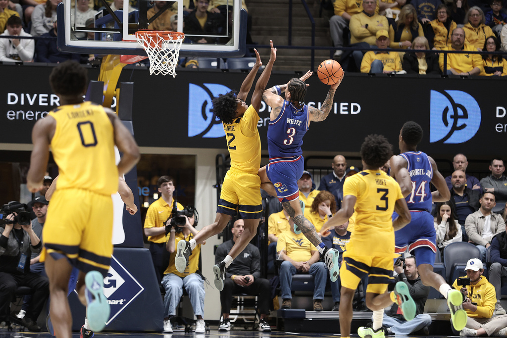 Kansas guard Tre White (3) is shoots while defended by West Virginia guard Amir Jenkins (2) during the first half of an NCAA college basketball game Saturday, Jan. 10, 2026, in Morgantown, W.Va. (AP Photo/Kathleen Batten)