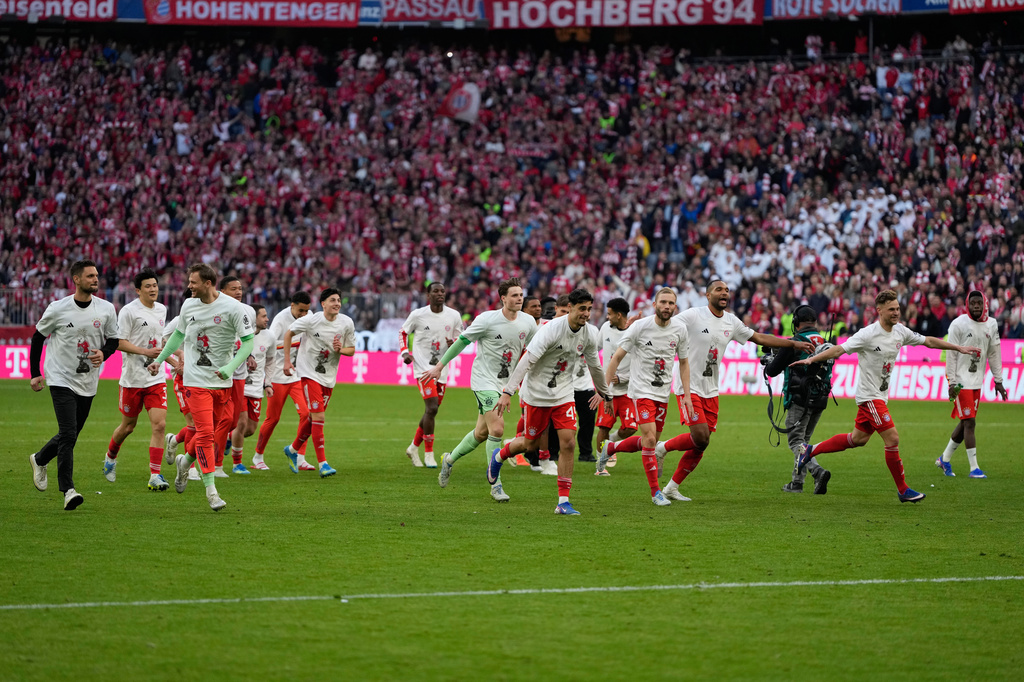 Bayern players celebrate after their team clinched the German league title after a Bundesliga soccer match between Bayern and Stuttgart in Munich, Germany, Sunday, April 19, 2026. (AP Photo/Matthias Schrader)