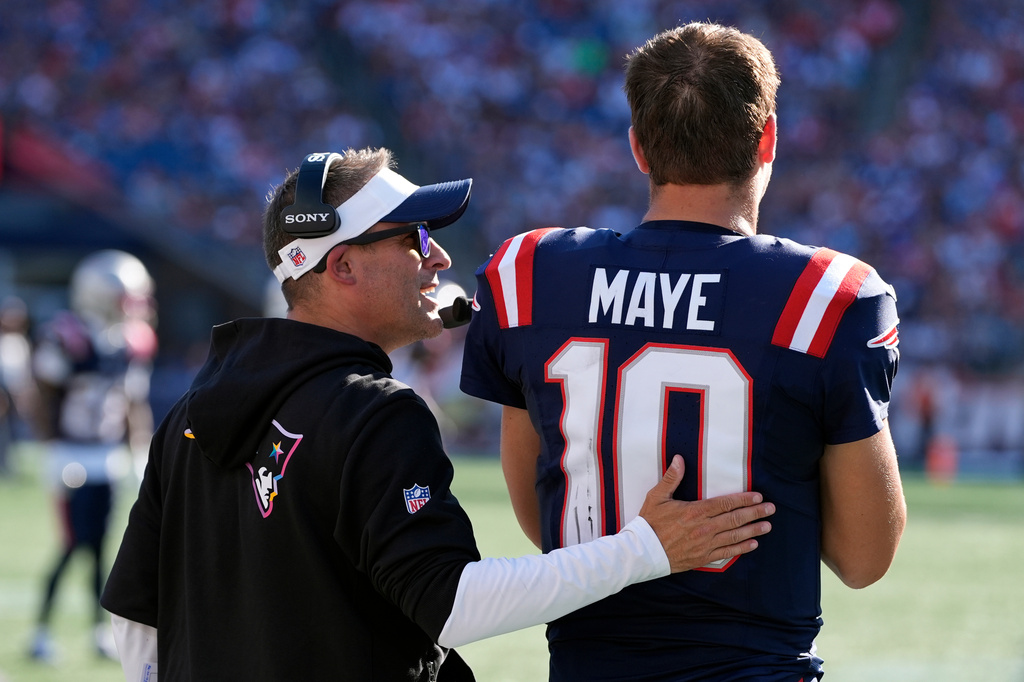 New England Patriots offensive coordinator Josh McDaniels, left, talks with quarterback Drake Maye (10) during the second half of an NFL football game against the Carolina Panthers, Sunday, Sept. 28, 2025, in Foxborough, Mass. (AP Photo/Charles Krupa)