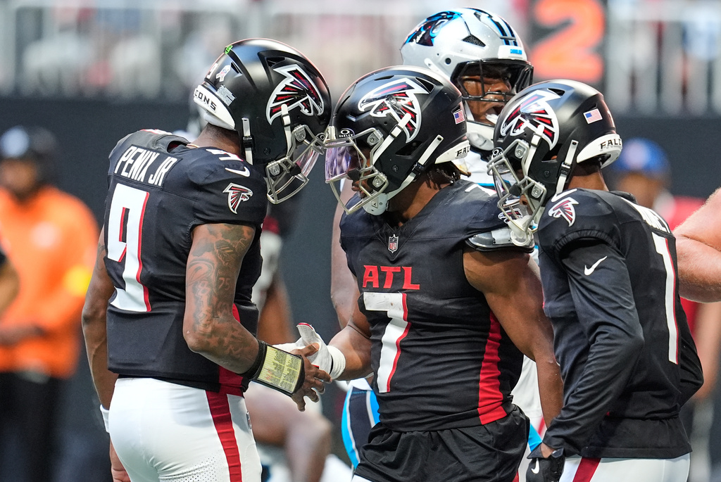 Atlanta Falcons running back Bijan Robinson (7) celebrates his touchdown with quarterback Michael Penix Jr. (9) in the first half of an NFL football game against the Carolina Panthers, Sunday, Nov. 16, 2025, in Atlanta. (AP Photo/Mike Stewart)