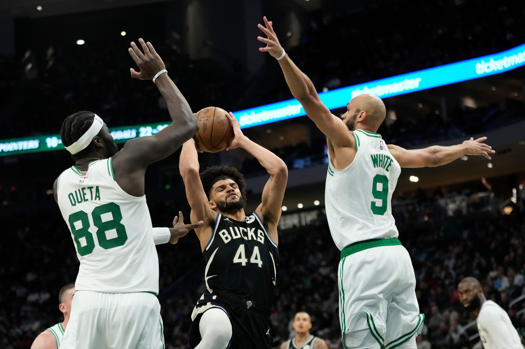 Milwaukee Bucks' Andre Jackson Jr. (44) drives to the basket between Boston Celtics' Neemias Queta (88) and Derrick White (9) during the first half of an NBA basketball game Friday, April 3, 2026, in Milwaukee. (AP Photo/Aaron Gash)
