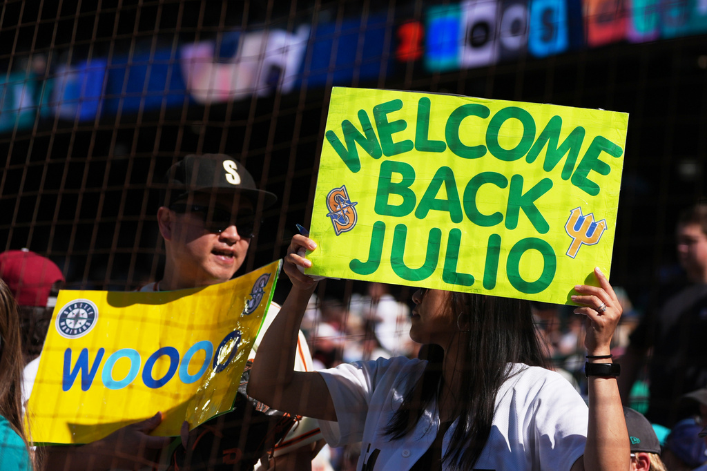 Fans hold signs for Seattle Mariners designated hitter Julio Rodríguez before a baseball game between the Seattle Mariners and the San Francisco Giants, Saturday, July 18, 2026, in Seattle. (AP Photo/Lindsey Wasson)