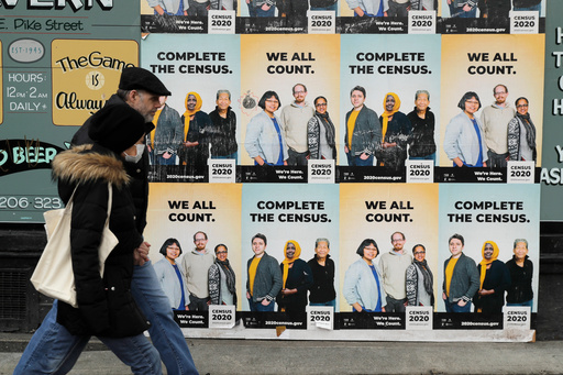 FILE - In this Wednesday, April 1, 2020 file photo,People walk past posters encouraging participation in the 2020 Census in Seattle's Capitol Hill neighborhood. (AP Photo/Ted S. Warren, File) FILE - In this Wednesday, April 1, 2020 file photo,People walk past posters encouraging participation in the 2020 Census in Seattle's Capitol Hill neighborhood. (AP Photo/Ted S. Warren, File)