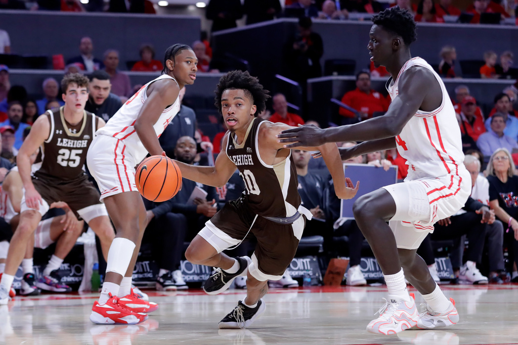 Lehigh guard Caleb Thomas (10) drives between Houston guard Mercy Miller, center left, and forward Kalifa Sakho, right, during the first half of an NCAA college basketball game Monday, Nov. 3, 2025, in Houston. (AP Photo/Michael Wyke)