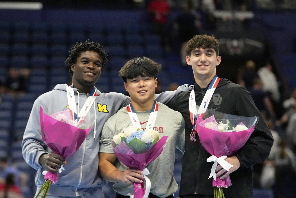Overall gold medal winner Asher Hong of Stanford University, center, poses with silver medal winner Frederick Richard of the University of Michigan, left, and bronze medal winner Fuzzy Benas of the University of Oklahoma, after the senior men's finals of the U.S. Gymnastics Championships in New Orleans, Saturday, Aug. 9, 2025. (AP Photo/Gerald Herbert)