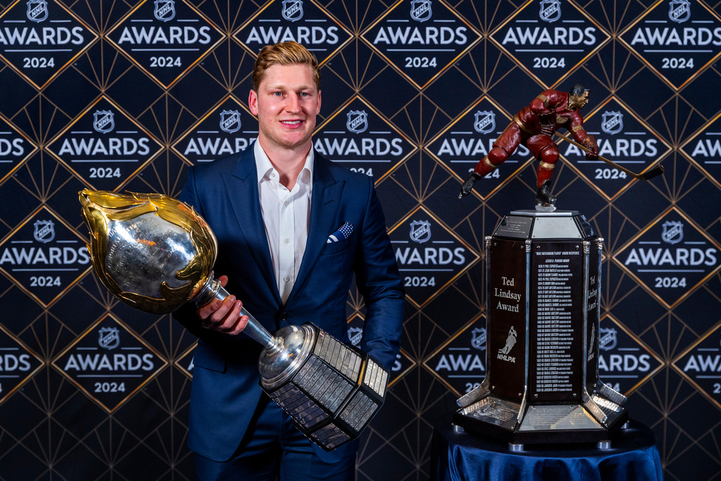 FILE - Colorado Avalanche forward Nathan MacKinnon stands with his trophies as the recipient of the Hart Memorial Trophy, left, and Ted Lindsay Award at hockey's NHL Awards, Thursday, June 27, 2024, in Las Vegas. (AP Photo/L.E. Baskow, File)