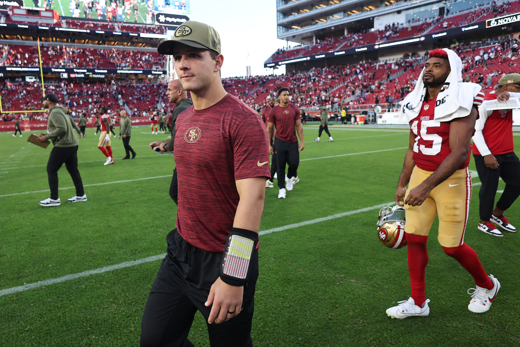 Injured San Francisco 49ers quarterback Brock Purdy, left, and wide receiver Jauan Jennings (15) walk off the field after an NFL football game against the Los Angeles Rams in Santa Clara, Calif., Sunday, Nov. 9, 2025. (AP Photo/Jed Jacobsohn)