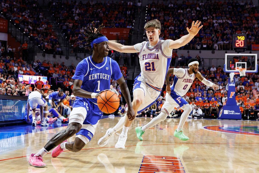 Kentucky guard Denzel Aberdeen (1) drives past Florida forward Alex Condon (21) during the first half of an NCAA college basketball game Saturday, Feb. 14, 2026, in Gainesville, Fla. (AP Photo/Chris Watkins)