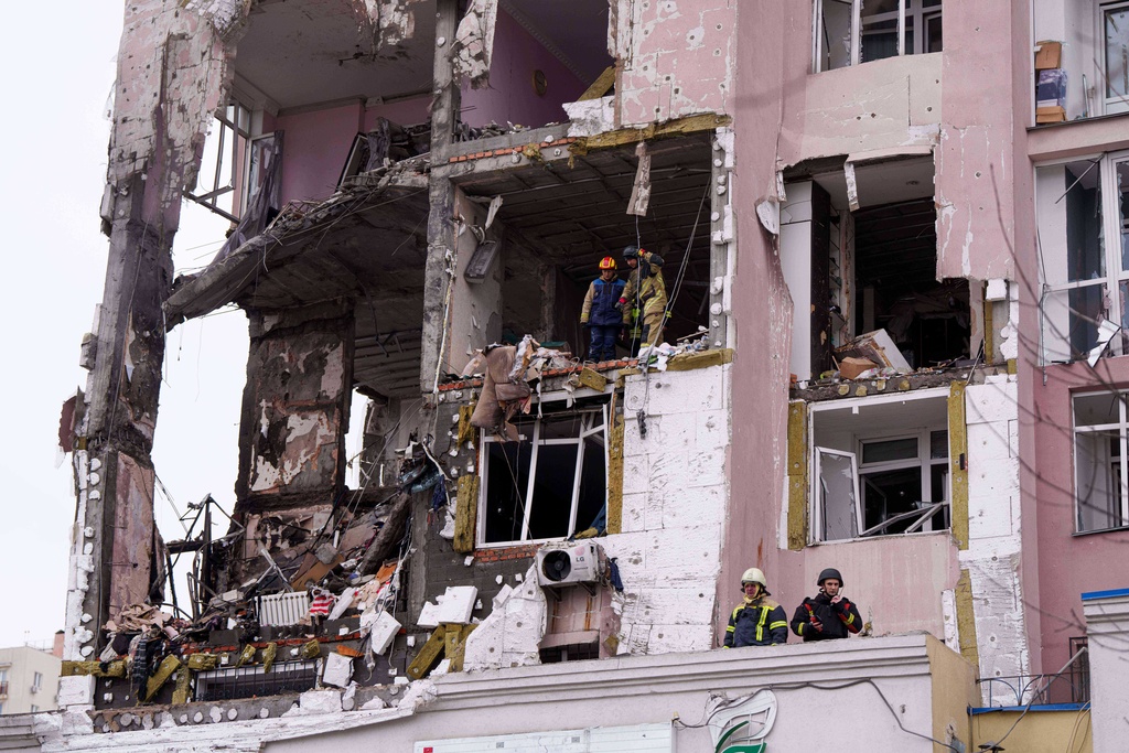 Rescue workers clear the rubble of a residential building which was heavily damaged after a Russian strike on Kyiv, Ukraine, on Saturday, Dec. 27, 2025. (AP Photo/Evgeniy Maloletka)