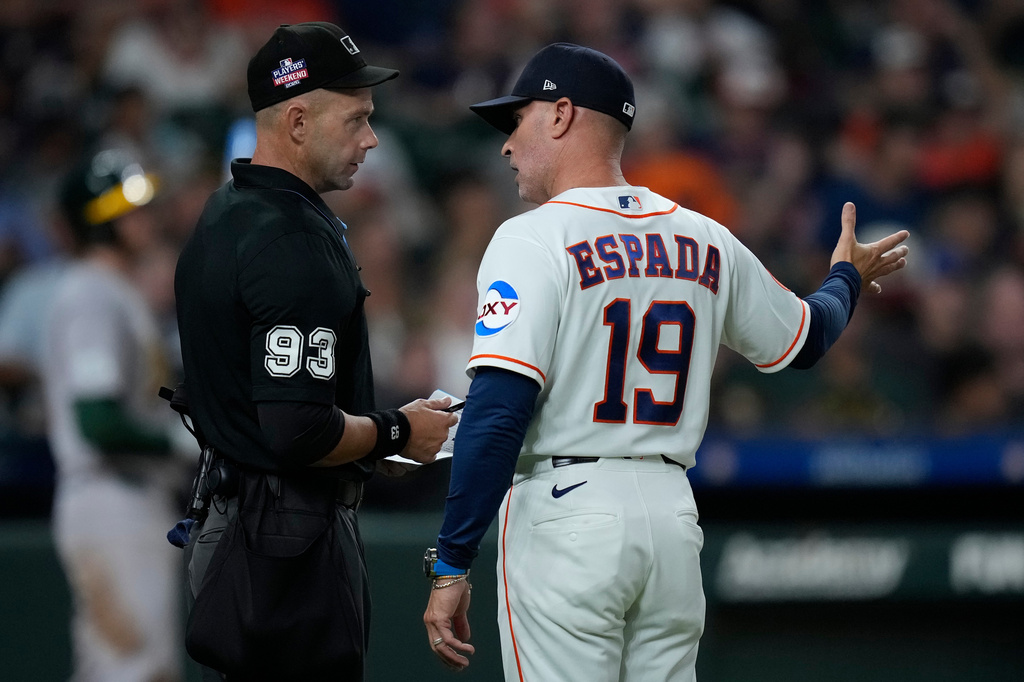 Home plate umpire Will Little (93) talks with Houston Astros manager Joe Espada (19) over a pitching change dispute during the sixth inning of a baseball game against the Athletics, Saturday, Aug. 22, 2026, in Houston. (AP Photo/Kevin M. Cox)