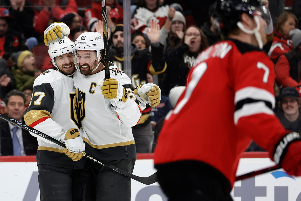 Vegas Golden Knights defenseman Shea Theodore (27) is congratulated after scoring a goal by Mark Stone (61) during the first period of an NHL hockey game against the New Jersey Devils, Friday, Dec. 5, 2025, in Newark, N.J. (AP Photo/Adam Hunger)