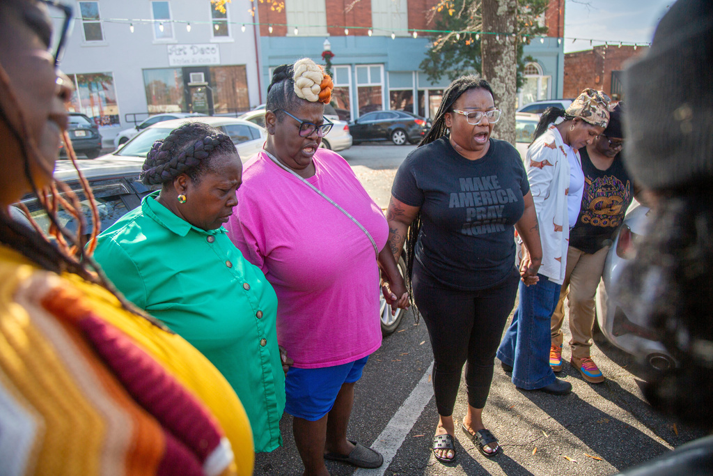 Eurie Martin's sister Helen Gilbert, second from left, prays with supporters outside the Washington County Courthouse during a break in jury deliberations in the murder trial of three former Washington County Sheriff's deputies accused of killing Martin in 2017 on Thursday, Nov. 20, 2025 in Sandersville, Ga. (Grant Blankenship/Georgia Public Broadcasting via AP)
