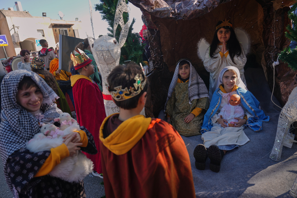 Wearing traditional costumes, children take part in the 40th annual Christmas parade heading towards the Basilica of the Annunciation in Nazareth, Israel, Wednesday, Dec. 24, 2025. (AP Photo/Ariel Schalit)