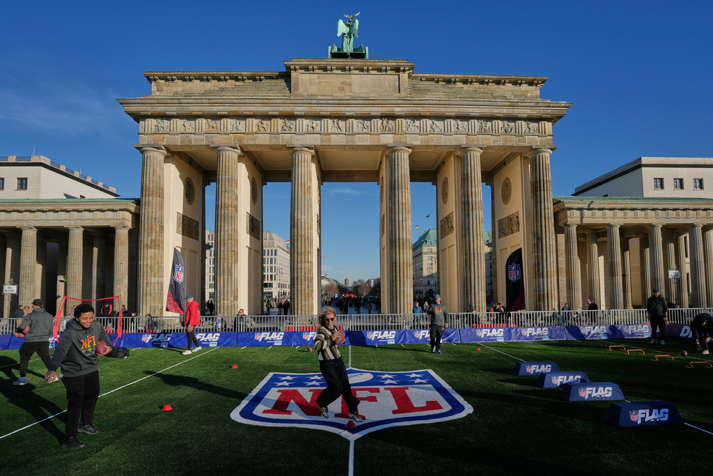A woman practices at the NFL Experience event in front of the Brandenburg Gate in Berlin, Germany, Thursday, Nov. 6, 2025. (AP Photo/Markus Schreiber)