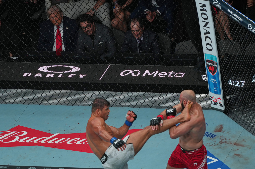 President Donald Trump and Hunter Campbell watch as Paulo Costa, left, and Azamat Murzakanov fight during UFC 327 at Kaseya Center, Saturday, April 11, 2026, in Miami. (AP Photo/Julia Demaree Nikhinson)