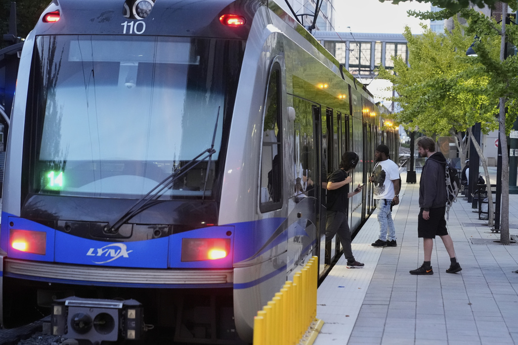People enter and exit a Charlotte Area Transit System light rail, Monday, Sept. 8, 2025, in Charlotte, N.C. (AP Photo/Erik Verduzco)