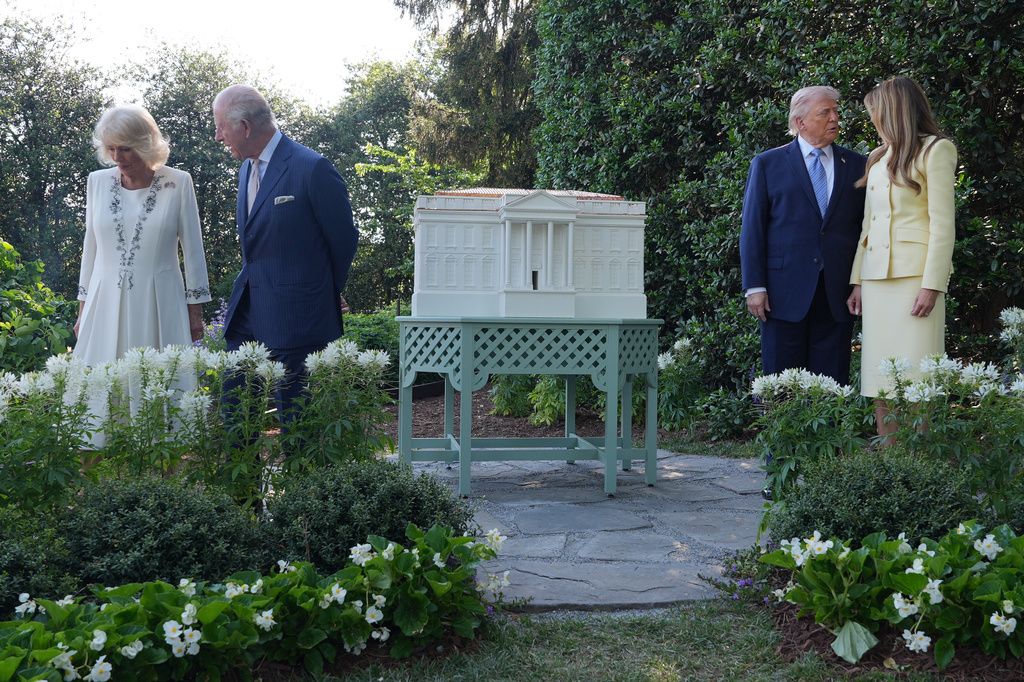 President Donald Trump and first lady Melania Trump along with Britain's King Charles III and Queen Camilla pose for a photo by White House bee hive at the White House, Monday, April 27, 2026, in Washington. (AP Photo/Alex Brandon, Pool)