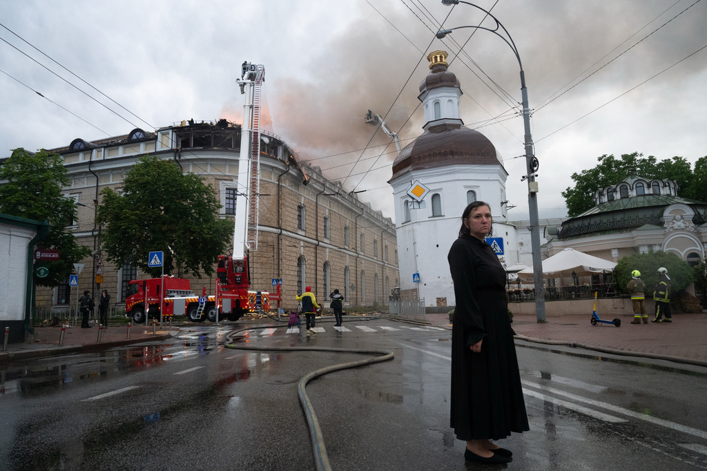 A woman stands at a street near a damaged building following an overnight Russian attack in Kyiv, Ukraine, Monday, June 15, 2026. (AP Photo/Danylo Antoniuk)