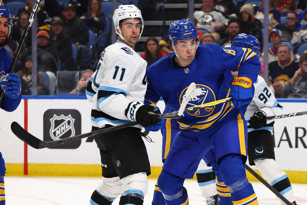 Utah Mammoth right wing Dylan Guenther (11) and Buffalo Sabres defenseman Michael Kesselring (8) battle for position during the second period of an NHL hockey game Tuesday, Nov. 4, 2025, in Buffalo, N.Y. (AP Photo/Jeffrey T. Barnes)