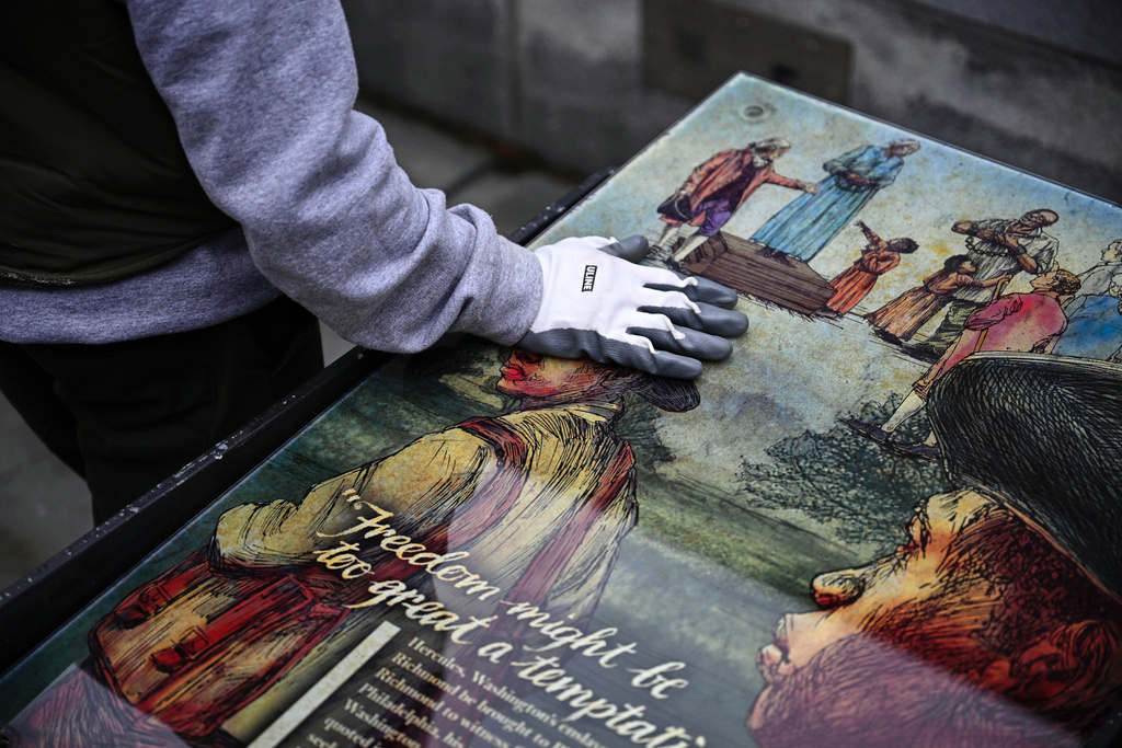 A National Parks Service worker puts his hand on a panel that was part of an exhibit on slavery at the President's House Site in Philadelphia to be put back Thursday, Feb. 19, 2026. (AP Photo/Joe Lamberti)