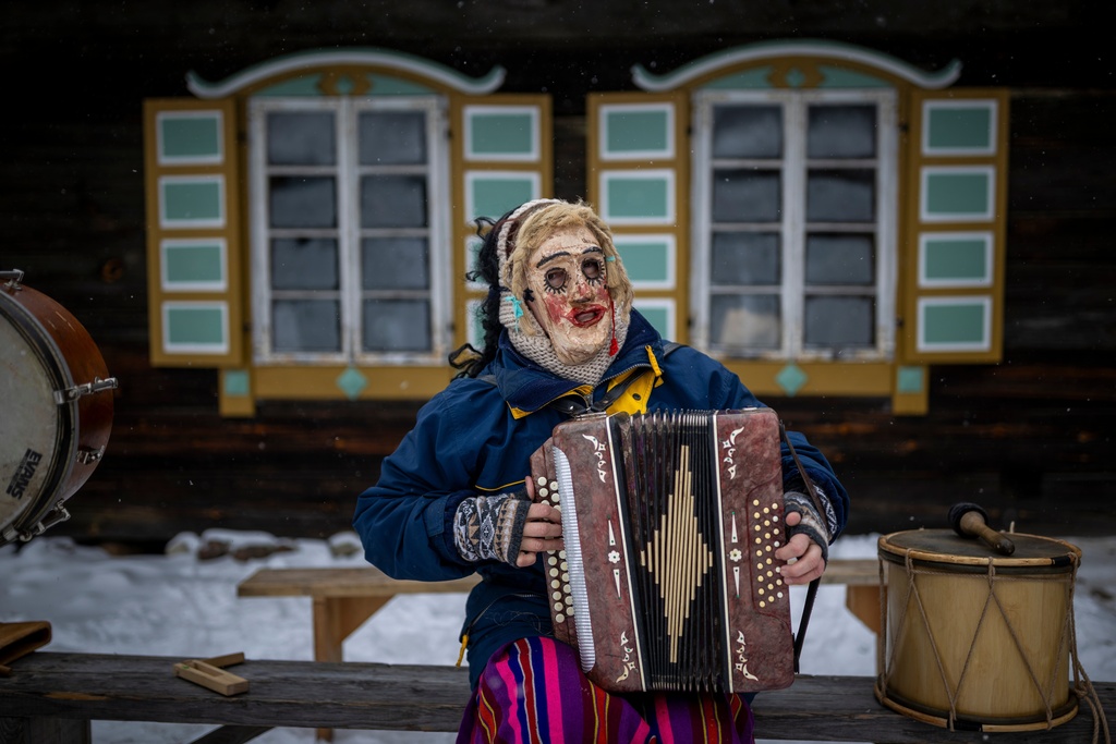A woman wearing traditional carnival masks takes part in Shrovetide celebrations in the village of Rumsiskes, some 89 kilometers (56 miles) north of Vilnius, Lithuania, Saturday, Feb. 14, 2026. (AP Photo/Mindaugas Kulbis)