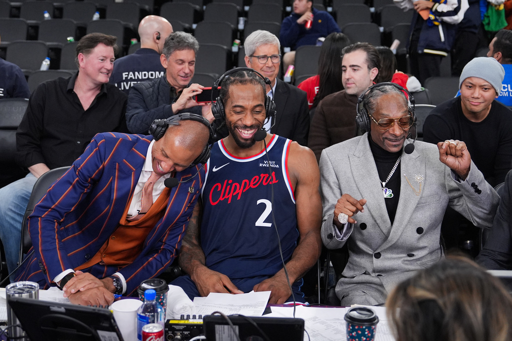 NBA analyst, Snoop Dogg, right, appears with Los Angeles Clippers forward Kawhi Leonard, center, and former NBA player and lead game analyst for NBC Sports, Reggie Miller, following the team's NBA basketball game against the Golden State Warriors, Monday, Jan. 5, 2026, in Inglewood, Calif. (AP Photo/Jae C. Hong)