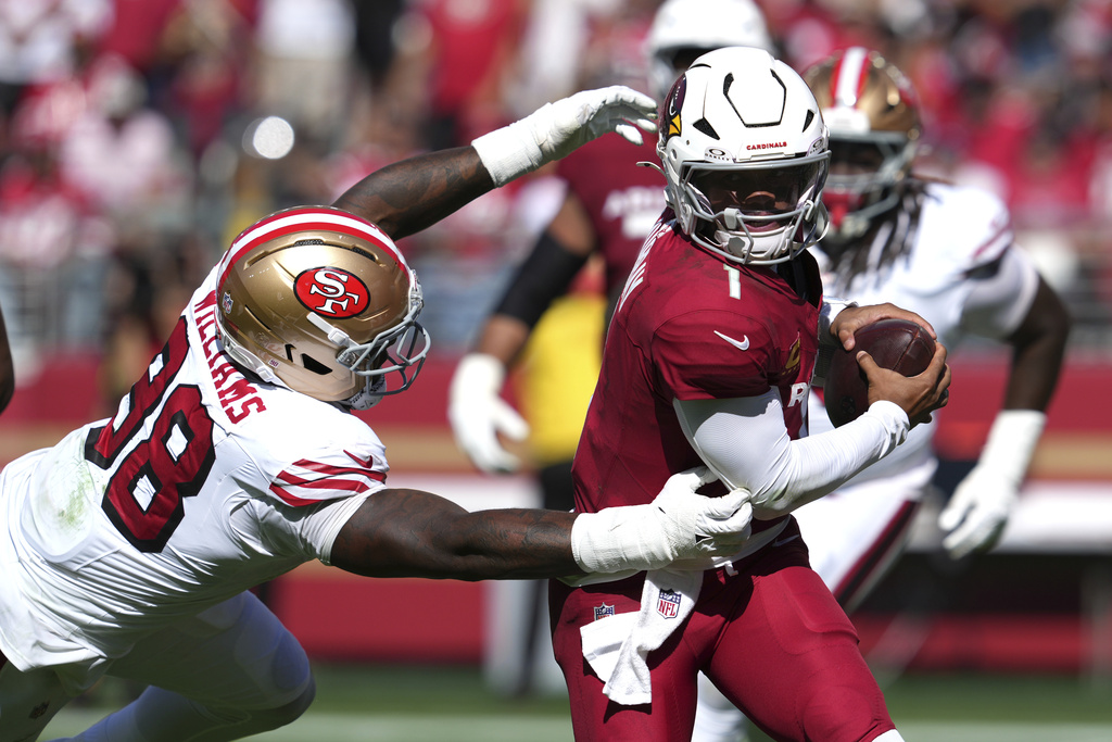 Arizona Cardinals quarterback Kyler Murray, right, avoids a tackle by San Francisco 49ers defensive end Mykel Williams during the second half of an NFL football game Sunday, Sept. 21, 2025, in Santa Clara, Calif. (AP Photo/Godofredo A. Vásquez)