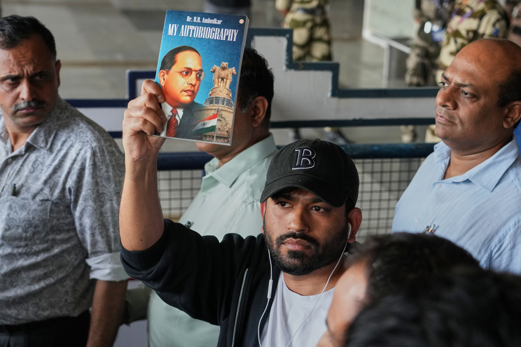 Abhijeet Dipke founder of Cockroach Janta Party shows the autobiography of Bhim Rao Ambedkar as he comes out at Indira Gandhi International airport in New Delhi, India, Saturday, June 6, 2026. (AP Photo/Manish Swarup)