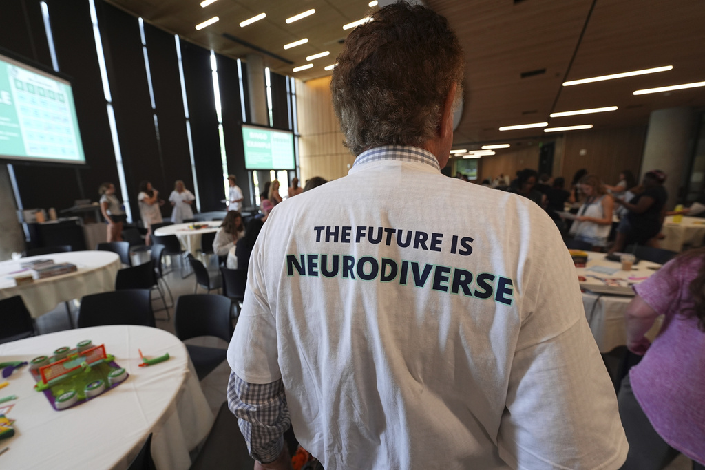 An attendee wears a shirt with a message during The Neurodiversity Alliance summit on the campus of the University of Denver Friday, Aug. 8, 2025, in Denver. (AP Photo/David Zalubowski)