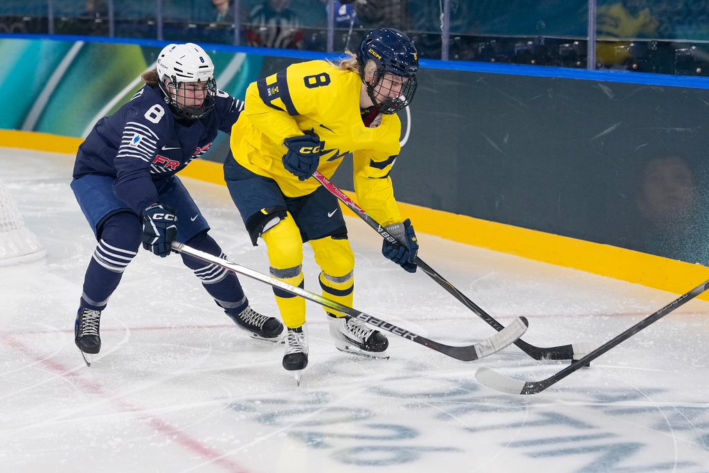 France's Jade Barbirati, left, challenges Sweden's Hilda Svensson during a preliminary round match of women's ice hockey between the France and Sweden at the 2026 Winter Olympics, in Milan, Italy, Sunday, Feb. 8, 2026. (AP Photo/Petr David Josek)