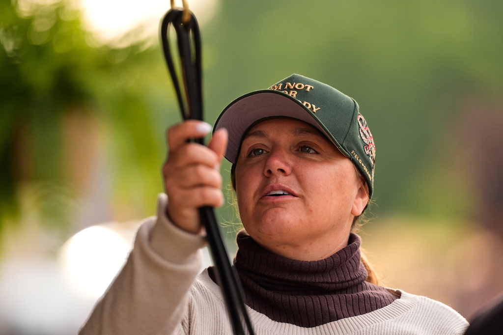 Trainer Cherie DeVaux stands watches from a barn after a workout at Churchill Downs Monday, April 27, 2026, in Louisville, Ky. (AP Photo/Charlie Riedel)