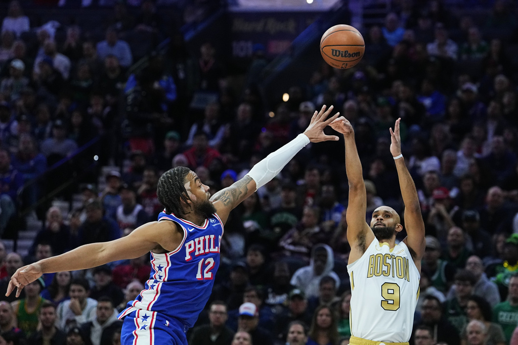 Boston Celtics' Derrick White (9) goes up to shoot against Philadelphia 76ers' Trendon Watford during the first half of an NBA basketball game Tuesday, Nov. 11, 2025, in Philadelphia. (AP Photo/Matt Rourke)