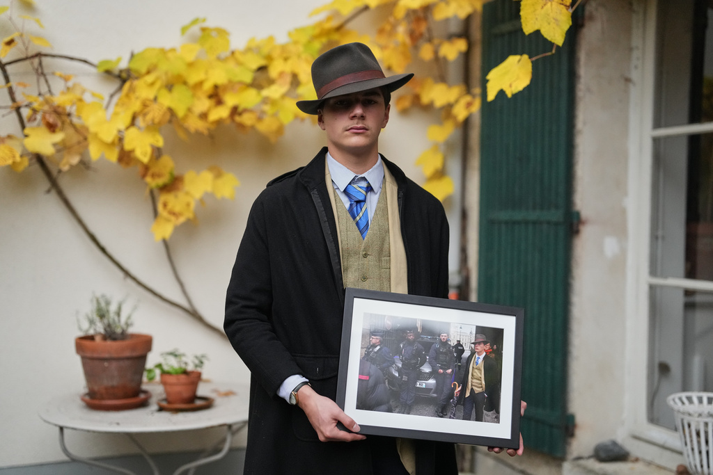 Pedro Elias Garzon Delvaux poses with an Associated Press photo of him outside the Louvre on the day of the crown jewels heist, Saturday, Nov. 8, 2025, in Rambouillet, south of Paris. (AP Photo/Thibault Camus)